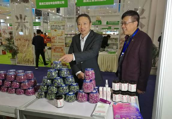 省委臺辦主任周敏謙(左)在四川雙龍農(nóng)牧開發(fā)有限公司展臺與臺商林云飛(右)親切交流