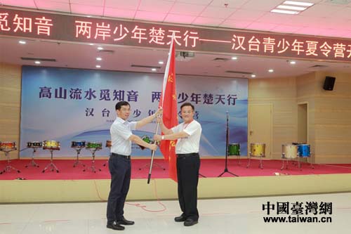 武漢市人民政府副市長盧沙野(左)向臺灣苗栗縣泰安鄉(xiāng)鄉(xiāng)長柯武勇授營旗