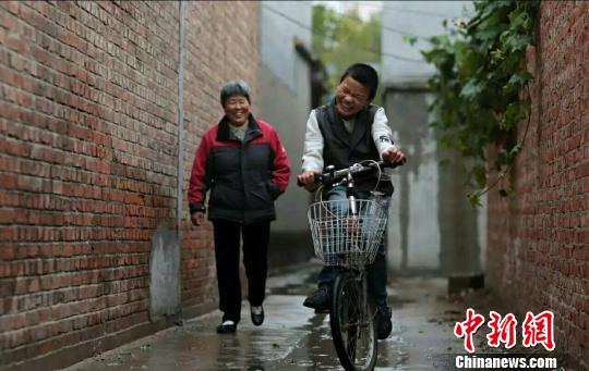 腦癱男孩遭遺棄保姆變身“媽媽”守候14年不悔(圖)