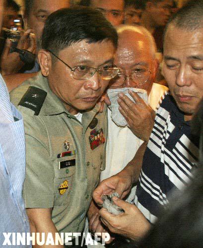 11月29日,菲律賓受審軍人頭目(左)與支持者被軍警帶出位于馬尼拉馬卡蒂金融區(qū)的半島酒店。一度占據(jù)酒店的受審軍人在政府壓力下被迫投降,受審軍人與政府對(duì)峙事件已經(jīng)結(jié)束。 新華社/法新